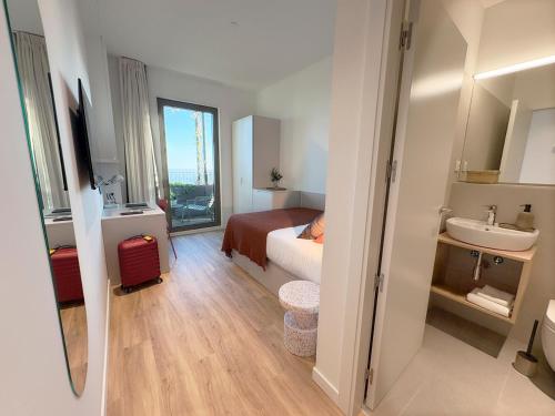 a bedroom with a bed and a sink and a bathroom at aparto Diagonal Suites in Esplugues de Llobregat