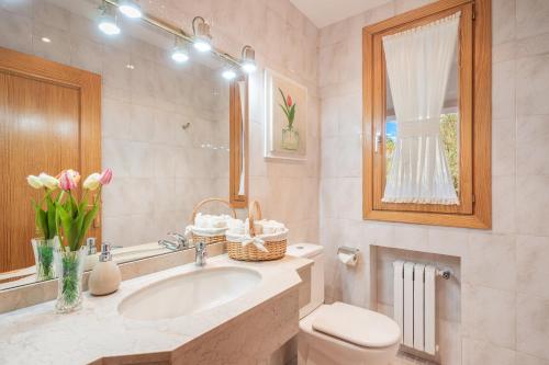 a bathroom with a sink and a toilet and a mirror at Vista Mar y Tierra in Marratxí 