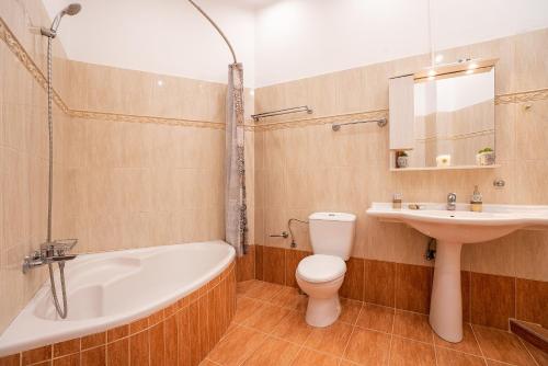 a bathroom with a sink and a toilet and a bath tub at Villa Nikolaos in Rhodes Town
