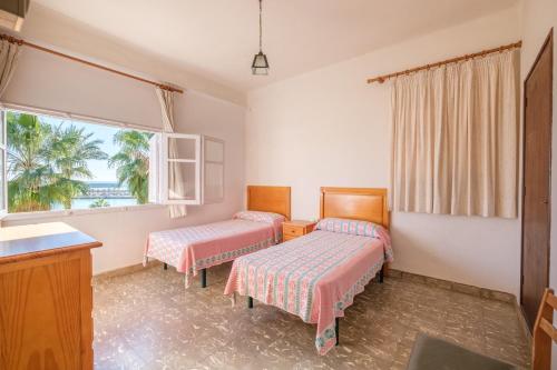 a room with two beds and a window at Apartamento las Palmeras 3 in Benicarló