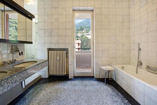 a bathroom with a tub and a sink and a bath tub at Appartamento Il Parco Cernobbio in Cernobbio