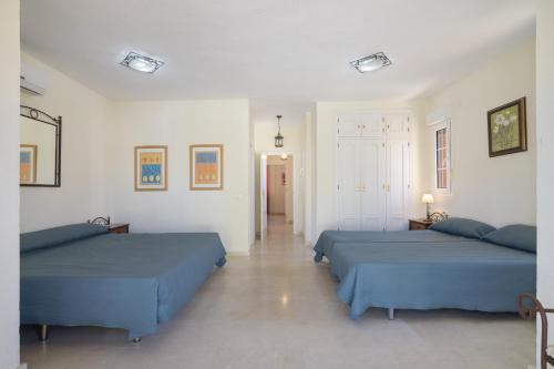 a bedroom with two beds and a hallway at Luxury villa in Islantilla