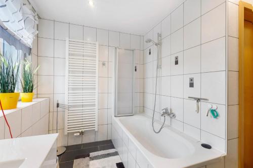a white bathroom with a tub and a shower at Ferienwohnung am Rosenberg in Stockach