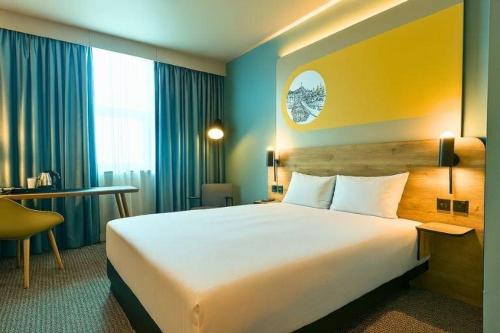 a hotel room with a large bed and a desk at B&B HOTEL Birmingham Centre in Birmingham