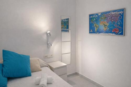 a bedroom with a blue pillow and a map on the wall at Tramuntana apart in Calafell