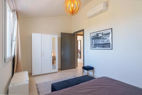 a bedroom with a bed and a chair in it at Il Sughereto In Vigna in Aglientu