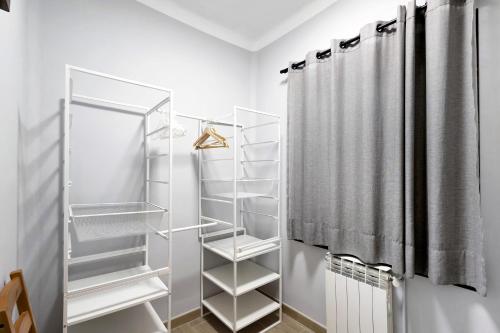a walk in closet with white shelves and a shower at Alfons I in Puigcerdà