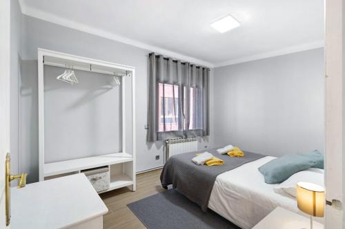 a white bedroom with a bed and a window at Alfons I in Puigcerdà
