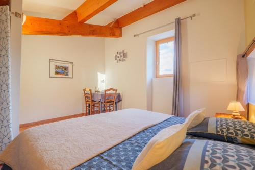 a bedroom with a large bed and a window at Perles De Aime in Laurac-en-Vivarais