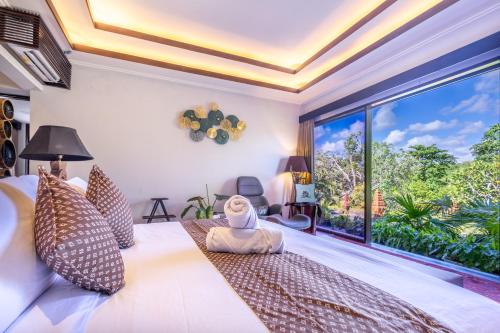 a bedroom with a bed and a large window at Villa Sulastri - Tanah Lot in Tanah Lot