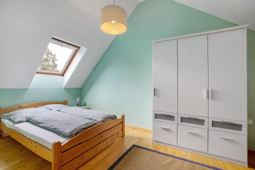 a bedroom with a bed with white cabinets and a window at Ferienwohnung Goelz in Bad Schussenried