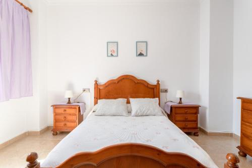 a bedroom with a wooden bed and two night stands at Apartamento Valle de Abdalajis in Málaga