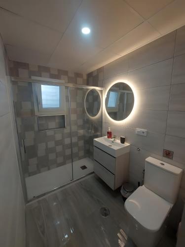 a bathroom with a toilet and a sink and a mirror at Casa Alex 1 in Zahora