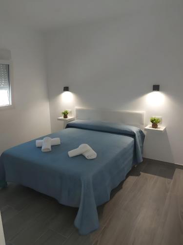 a bedroom with a blue bed with two towels on it at Casa Alex 1 in Zahora