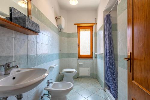 a bathroom with a sink and a toilet at House Leoni in Isola Rossa