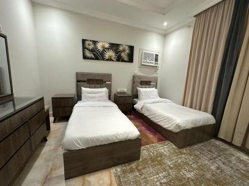 a room with two beds and a television in it at شقة المطيري in Jeddah
