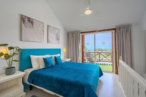a bedroom with a blue bed and a balcony at 1bed Duplex Las Americas in Playa de las Americas