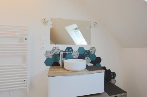 a bathroom with a sink and a mirror at Gîte Kerli cosy 2kms plage in Trévou-Tréguignec