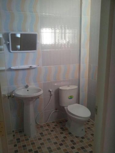 a bathroom with a toilet and a sink at Grand Pruksa Siri Apartment in Sara Buri