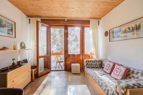 a living room with a couch and a window at Slalom 73 few Steps from Skiing - Happy Rentals in Bardonecchia
