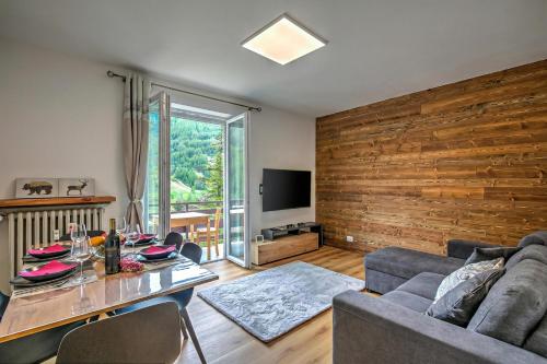 a living room with a wooden accent wall and a table at Starkeeper Apartment - Happy Rentals in Pragelato