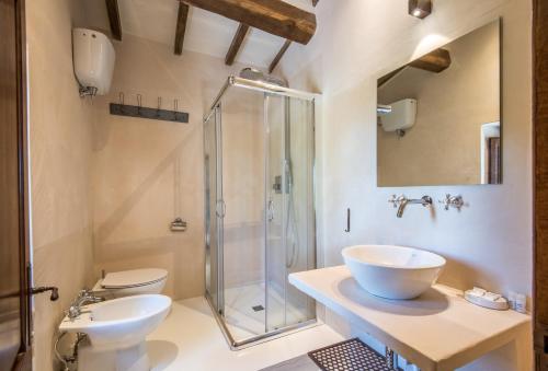 a bathroom with a glass shower and a toilet and sink at Appartamento Gemma Verde-tavoleto in Castiglione dʼOrcia