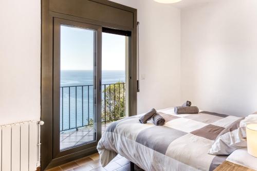 a bedroom with a bed and a view of the ocean at Casa Con Vistas Aiguablava in Tamariu