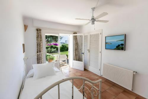 a bedroom with a bed and a balcony at La Chamade Cala Dor in Santanyi