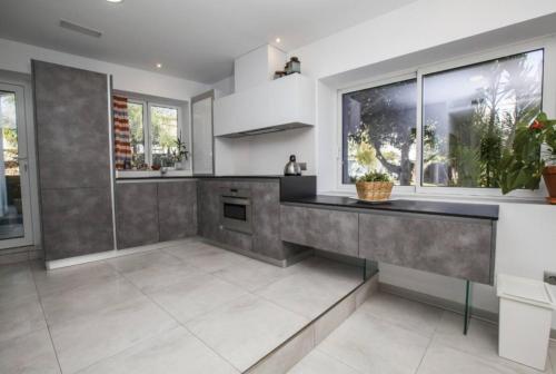 a kitchen with white appliances and gray walls at San Salvador apartamento in Nerja