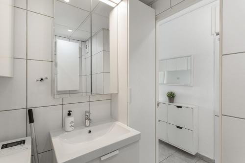 a white bathroom with a sink and a mirror at Vistas al atlantico in Puerto Rico de Gran Canaria