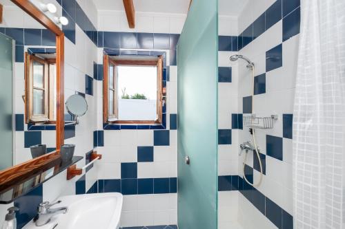 a bathroom with blue and white tiles and a sink at Villa Solivent in Es Mercadal