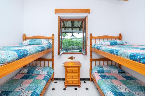 a room with three bunk beds and a window at Villa Solivent in Es Mercadal
