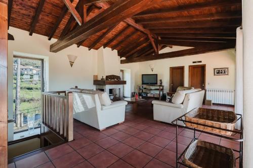 a living room with two white chairs and a television at Turismo Rural No Gerês in Carvalheira