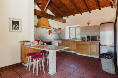 a kitchen with a large island with bar stools at Turismo Rural No Gerês in Carvalheira