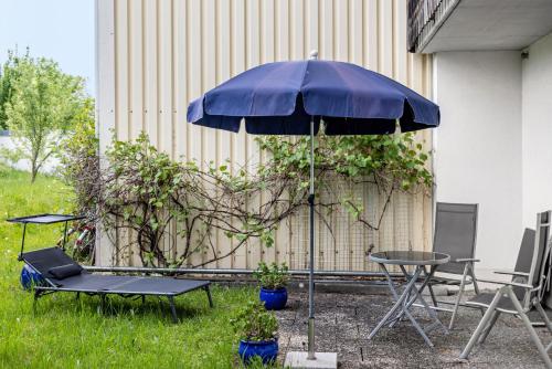 a blue umbrella sitting next to a table and chairs at Ferienwohnung-4you in Sigmarszell