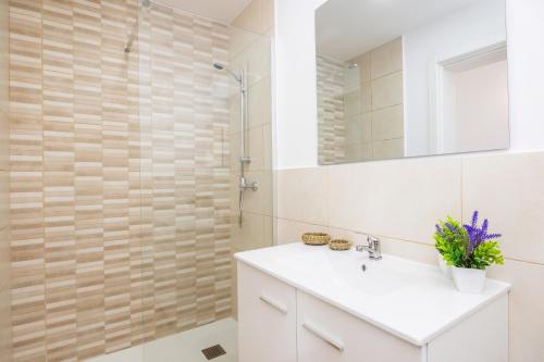 a bathroom with a white sink and a shower at Gran Sol Family 7 in Felanitx