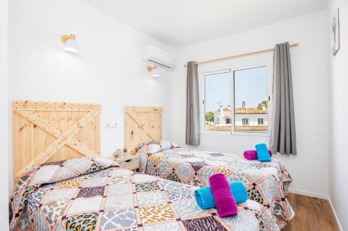 a bedroom with two beds and a window at Gran Sol Family 7 in Felanitx