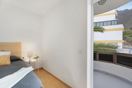 a bedroom with a bed and a balcony at Vivir Bajamar in Bajamar