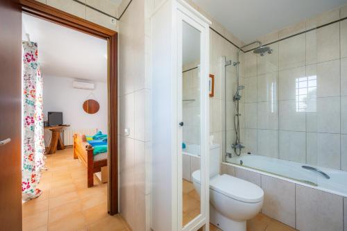 a bathroom with a toilet and a bath tub at Luna in Cala d´Or