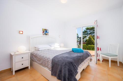 a bedroom with a bed and a chair and a window at Luna in Cala d´Or