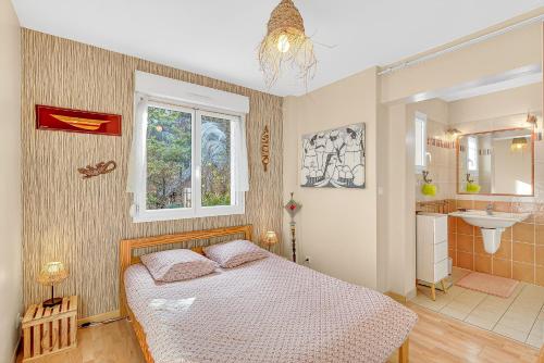 a bedroom with a bed and a bathroom with a sink at Cap à Gap T2 Bas De Villa in Gap