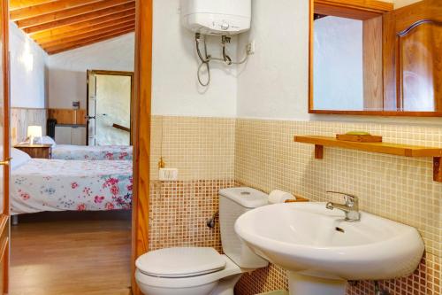 a bathroom with a toilet and a sink and a bed at Mirador de Domingo in Gáldar