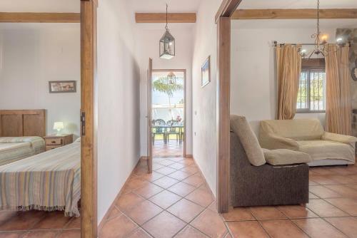 a bedroom with a bed and a chair in a room at Villa Conilsur in Conil de la Frontera
