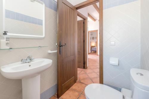 a bathroom with a white sink and a toilet at Villa Conilsur in Conil de la Frontera