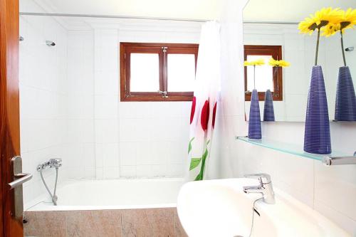 a bathroom with a tub and a toilet and a sink at Villa Animeta in Port de Pollensa