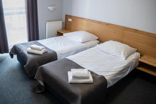 two beds in a hotel room with towels on them at Hotel Galion in Gdańsk