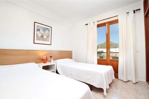 a hotel room with two beds and a window at Villa Animeta in Port de Pollensa
