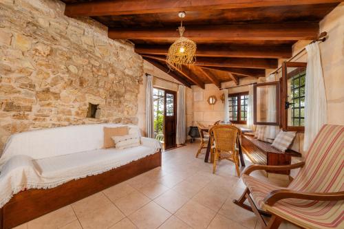 a bedroom with a bed and a stone wall at Es Colomer in Petra