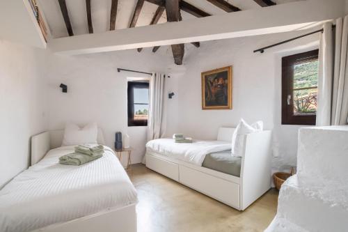 two beds in a room with white walls at Les 3 vues in Tourrettes-sur-Loup