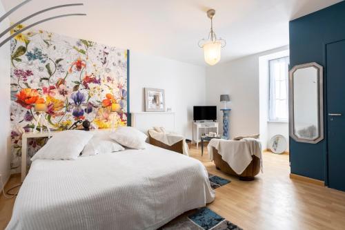 a bedroom with a white bed and a painting on the wall at L'Eclose Chambre Ildut in Le Guilvinec